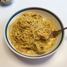 a white bowl filled with pasta on top of a table