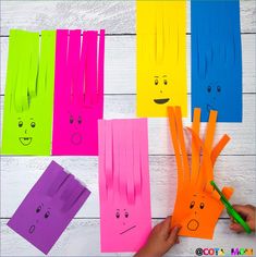 paper cut out to look like faces on different colored papers with marker pens and scissors