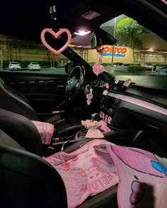 the interior of a car is decorated with pink and white items, including t - shirts