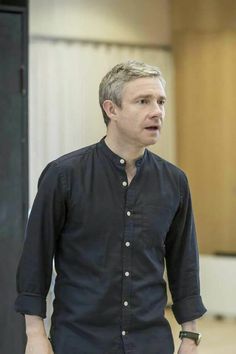 a man standing in front of a podium with his hand on his hip and looking off to the side