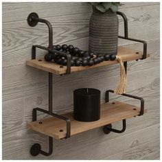 two wooden shelves with black balls on them and a vase next to one that has a candle in it