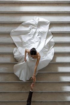 an aerial view of a bride and groom holding hands in front of the stairs at their wedding reception