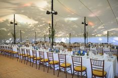 the tables are set up with white linens and yellow chairs for an elegant event