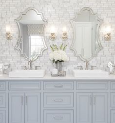 a bathroom with two sinks and mirrors on the wall next to each other in front of a white brick wall