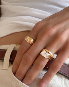 a woman's hand with two gold rings on it