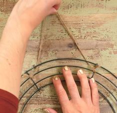 a woman's hand is on top of a circular object with wire attached to it