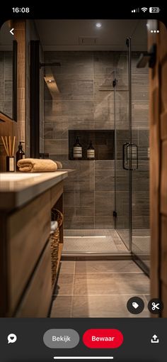 a bathroom with a walk in shower sitting next to a sink and a wooden cabinet