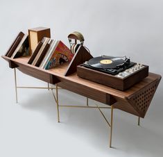 a record player on a wooden table with books