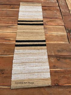 a striped rug is laying on top of a wooden floor with the words ground art rugs written across it