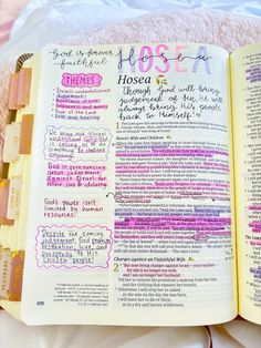 an open bible on a bed with writing in pink and purple ink, next to a cup of coffee