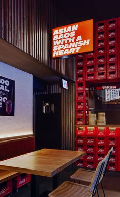 the inside of a fast food restaurant with wooden tables and red boxes on the wall