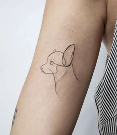 a woman's arm with a small tattoo of a dog on the left side