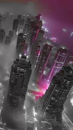 an aerial view of a city at night with skyscrapers and fog in the foreground