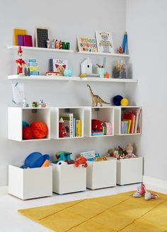 a child's room with toys and bookshelves on the wall above it