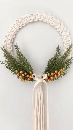 a white bracelet with gold beads and pine cones on it, tied to a string