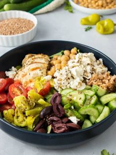 a black bowl filled with different types of vegetables and meat on top of a table