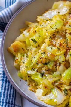 a bowl filled with cabbage and onions on top of a blue and white checkered table cloth