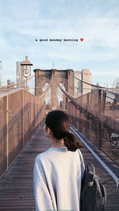 a woman is standing on a bridge with her back to the camera