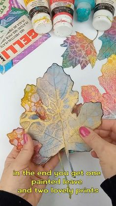 someone is painting leaves with acrylic paint on the paper and then they are painted