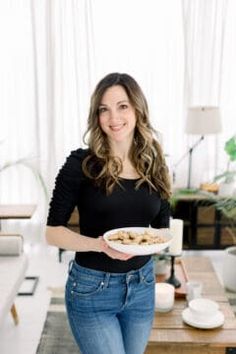 a woman holding a plate of food in her hands