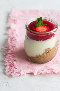 a dessert in a glass jar with strawberries on top