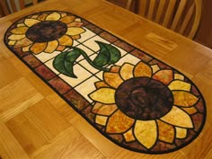 a sunflower stained glass door mat sitting on top of a wooden floor next to a chair