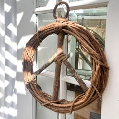 a peace sign made out of branches hanging from a window sill in front of a building