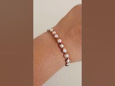 a woman's arm wearing a bracelet with pearls