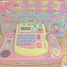 a pink and yellow electronic toy on the floor next to a box with an animal theme