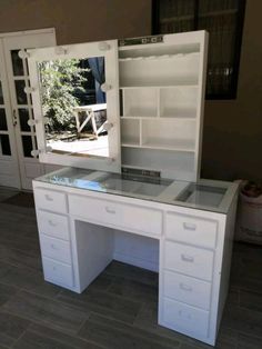 a white desk with drawers and a mirror