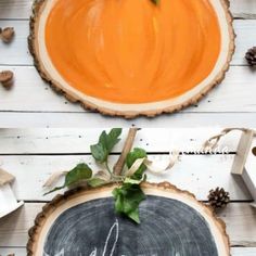 an orange painted pumpkin sitting on top of a wooden slice with the word hello autumn written on it