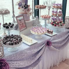 a table topped with lots of cakes and cupcakes