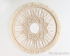 a white wall hanging with a circular design on it