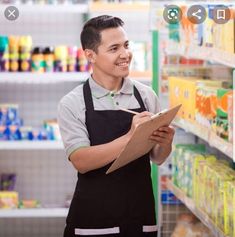 a man in an apron holding a clipboard while standing next to a grocery store shelf