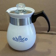 a white and blue coffee pot sitting on top of a table