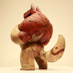 an elephant figurine made out of wood with red paint on it's face