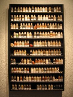 a large shelf filled with lots of different types of medicine bottles on it's sides