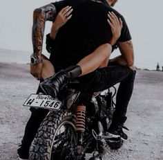 a man riding on the back of a motorcycle while holding onto another man's arm