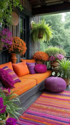 an orange couch sitting on top of a wooden floor next to potted plants and flowers