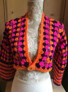 a crocheted jacket is displayed on a mannequin