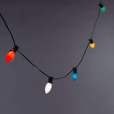 multi - colored christmas lights are hanging on a string