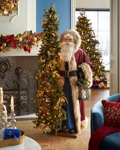 a man dressed as santa claus standing next to a christmas tree