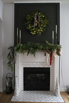 a fireplace decorated for christmas with wreaths and garland on it's mantel