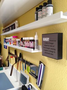 the wall is filled with many different types of hair care products on shelves, including scissors and combs