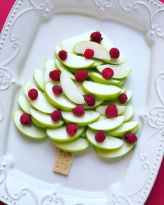 a white plate topped with sliced apples and raspberries