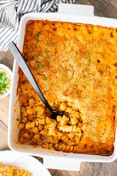 a casserole dish filled with macaroni and cheese on a wooden table