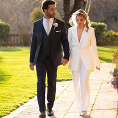 the bride and groom are walking down the path