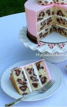 a cake with pink frosting and chocolate swirls on top is cut in half