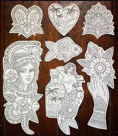 some paper cut outs that are on top of a wooden table with flowers and fish