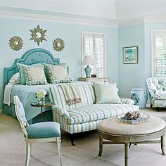 a bedroom with blue walls and furniture in the corner, along with windows that have shutters on them